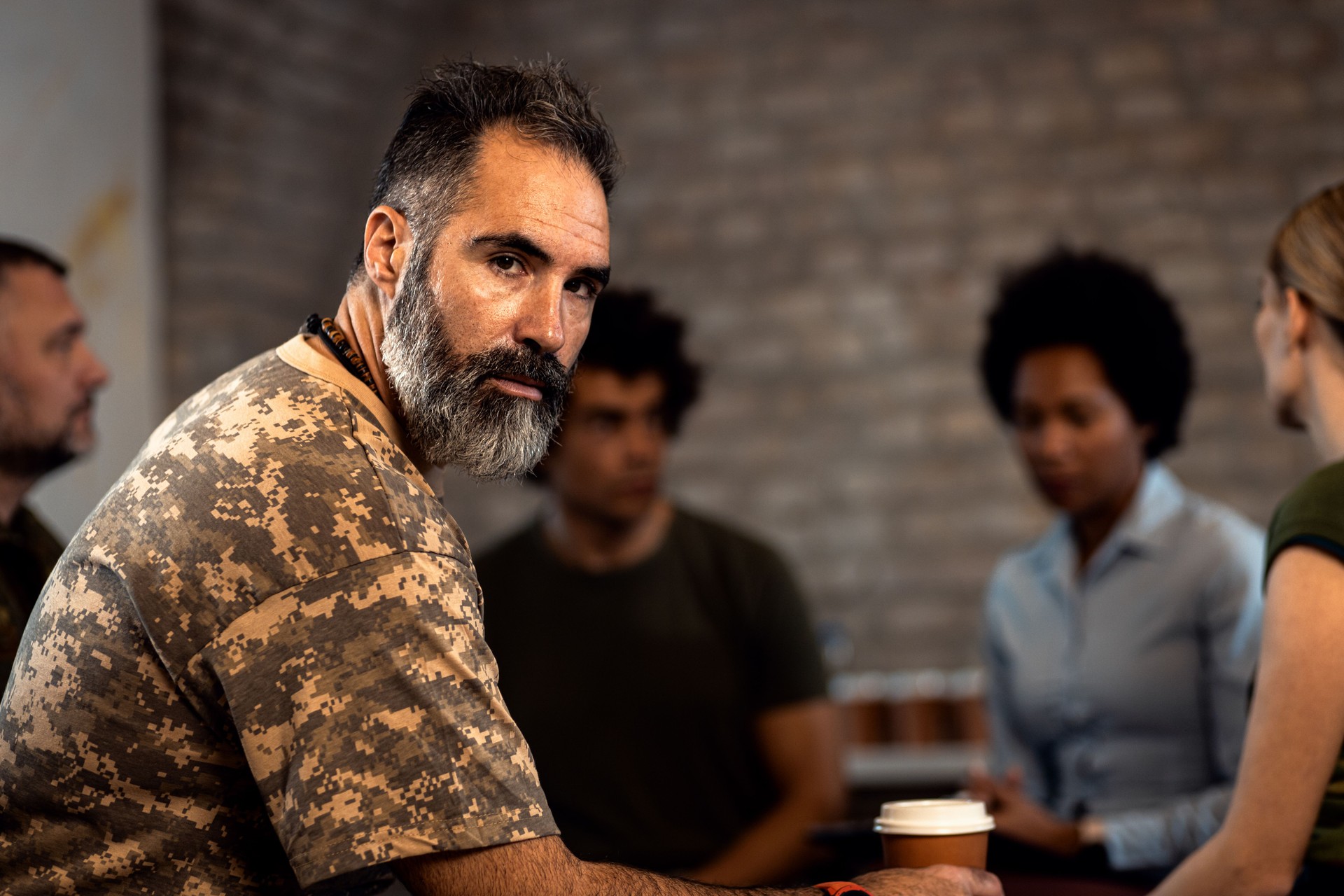 Portrait of male veteran in PTSD support group looking at camera.