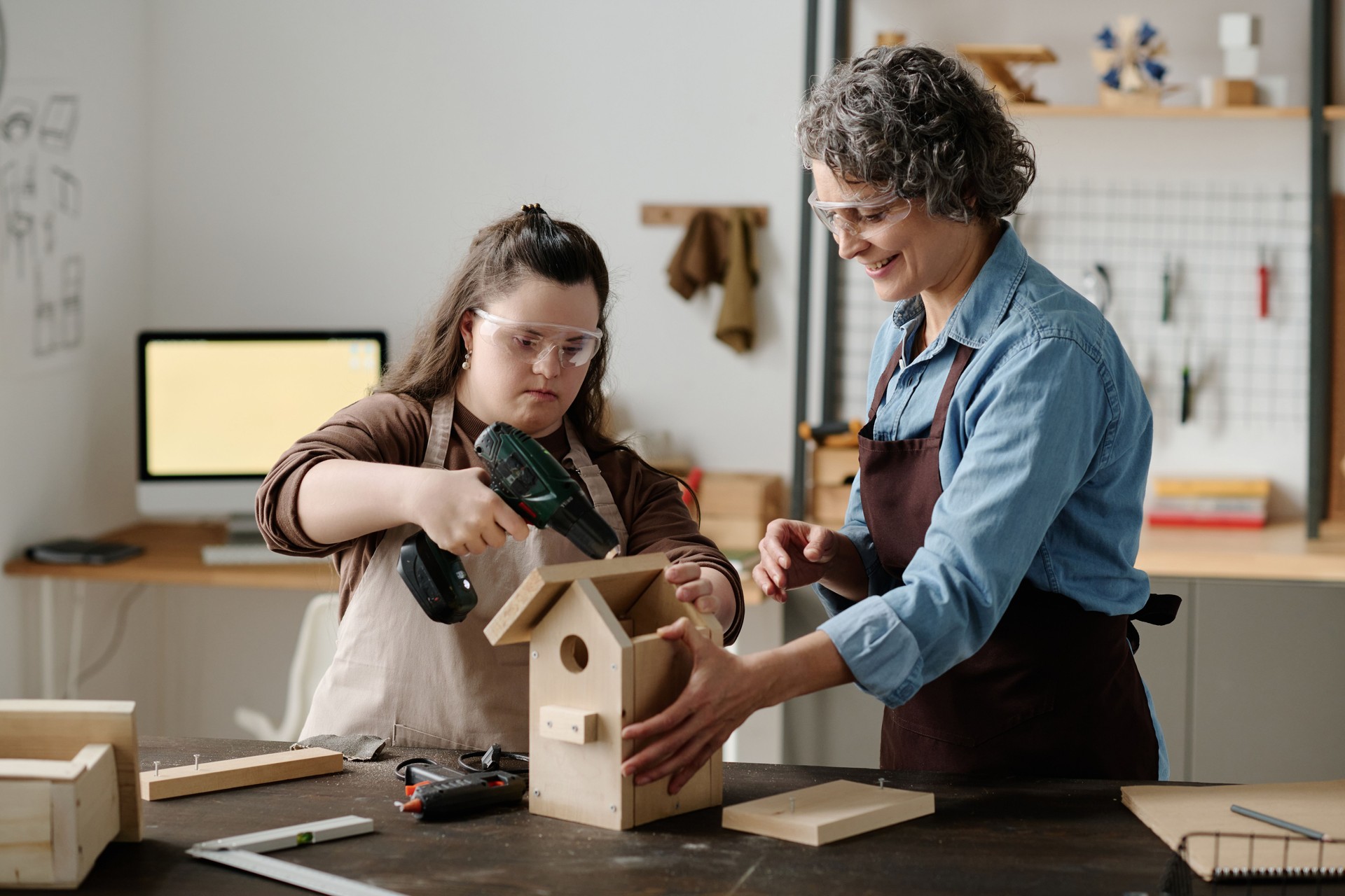 Girl with down syndrome making a wooden birdhouse